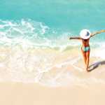 Young woman with arms apart on sand beach