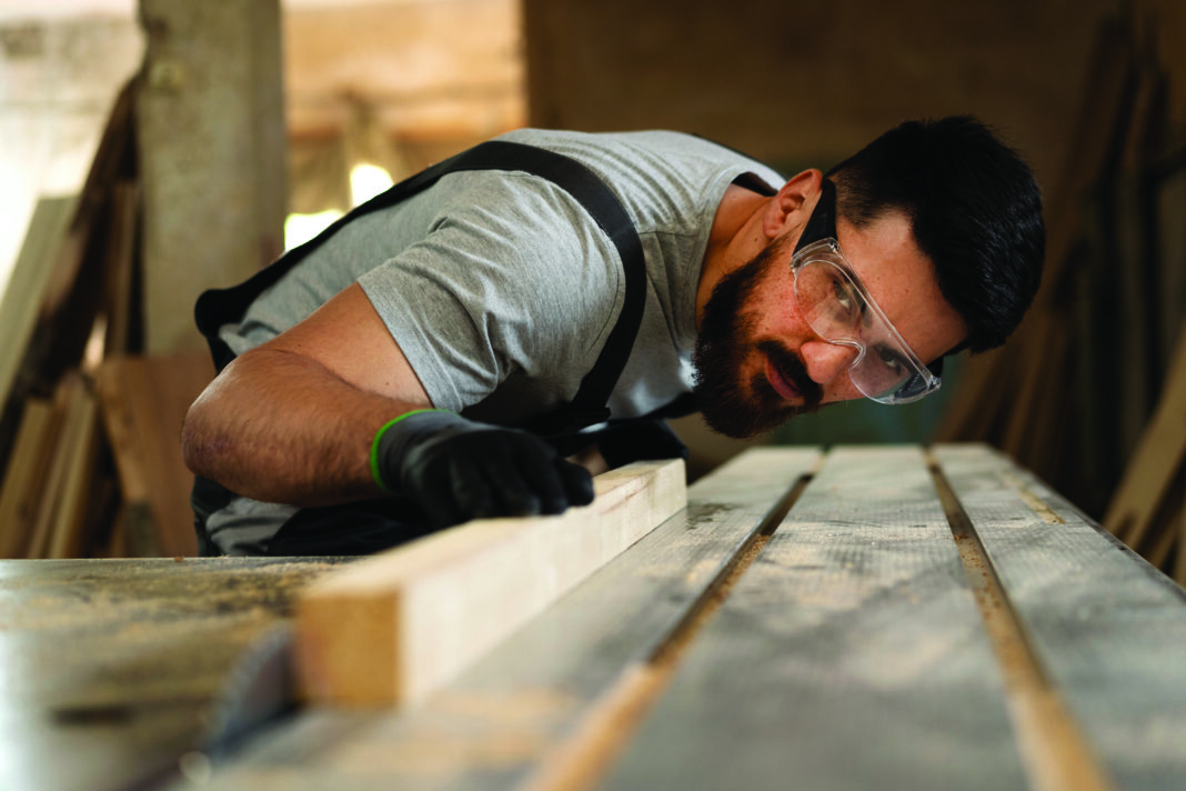 carpenter-cutting-MDF-board-inside-the-workshop