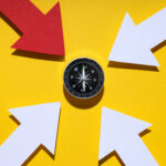 Dark compass on bright background, top view.