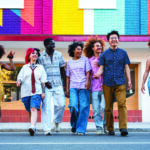 Multiethnic group of young friends meeting and having fun outdoo